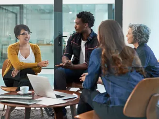 Business people brainstorming around a laptop